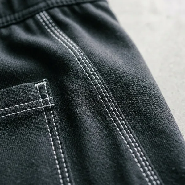 Detail jahitan kontras pada celana training sebagai elemen desain sportswear