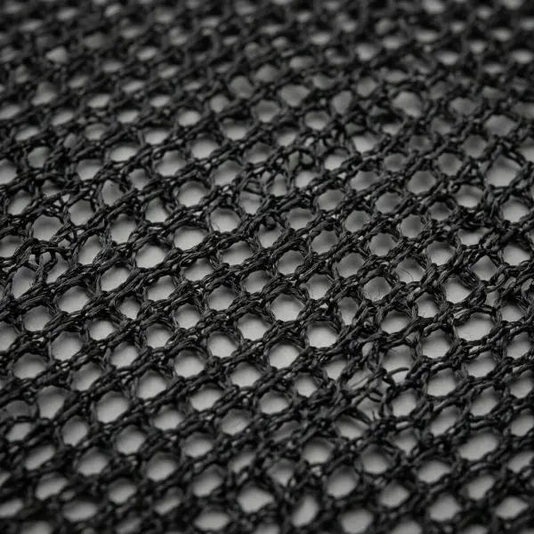 Macro close-up of black polyester mesh fabric showing interconnected yarns and evenly spaced open holes Macro close-up of black polyester mesh fabric showing interconnected yarns and evenly spaced open holes