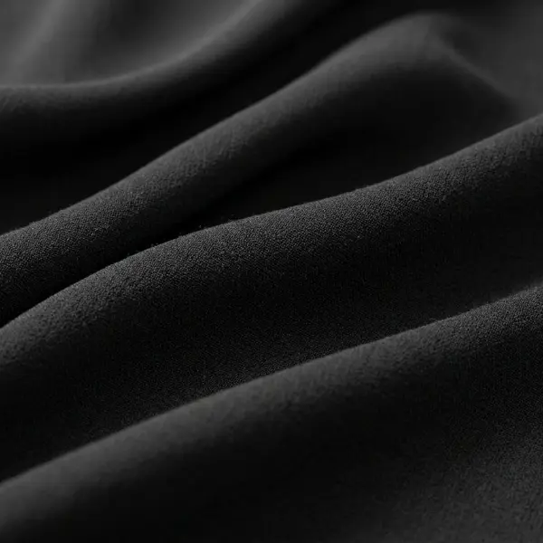 Fotografi detail permukaan kain hitam dengan pencahayaan terkontrol untuk memperlihatkan tekstur
