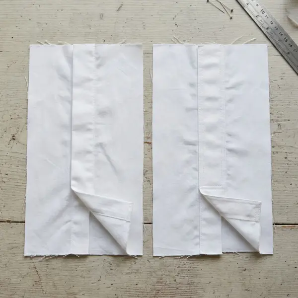 Tailoring worktable showing a folded shirt placket and a separately applied placket on cotton fabric samples