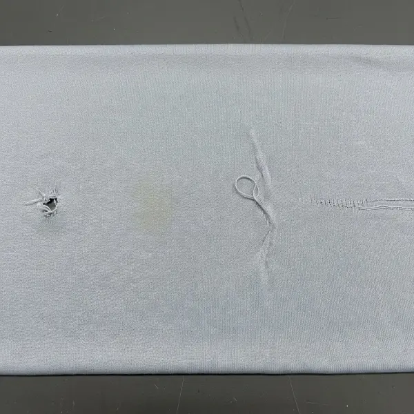 Contoh cacat bahan kaos PE berupa lubang kecil, benang tertarik, noda, dan garis tidak seragam pada permukaan kain Contoh cacat bahan kaos PE berupa lubang kecil, benang tertarik, noda, dan garis tidak seragam pada permukaan kain